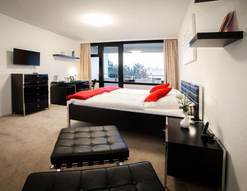 汉诺威艾林瑞德斯提福特公寓酒店的一间卧室配有一张带红色枕头的大床