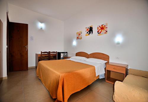 兰佩杜萨兰佩杜萨丽城酒店的一间卧室配有一张大床和一张沙发