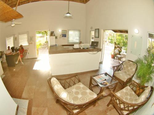 曼萨尼约Villas del Palmar Manzanillo with Beach Club的客厅配有椅子和柜台,可供人使用