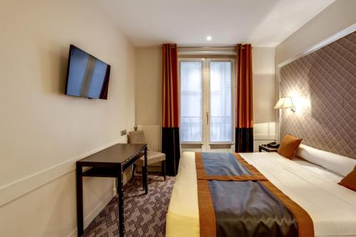 巴黎艾米安酒店的配有一张床和一张书桌的酒店客房