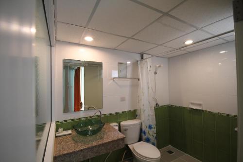 北榄府J住宿酒店的绿色和白色的浴室设有卫生间和水槽