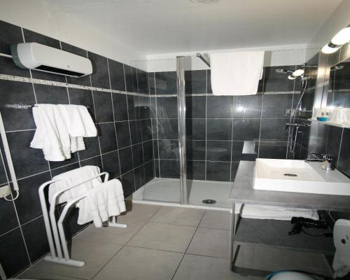 滨海福斯The Originals City, Hôtel Azur, Fos-sur-Mer的带淋浴和毛巾水槽的浴室