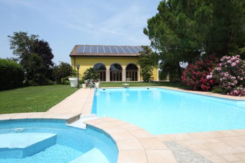 Curtatone科尔特卡皮路皮亚农家乐的一座带房子的庭院内的游泳池