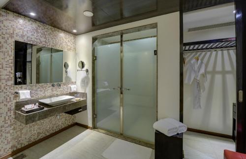 钦奈E酒店的一间带玻璃淋浴和水槽的浴室