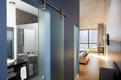 蒙特利尔乐多芬蒙特利尔中心维莱酒店的浴室设有玻璃门,可通往卧室
