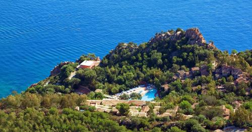 阿尔巴塔克斯Arbatax Park Resort - Borgo Cala Moresca的水中的岛屿,上面有房子