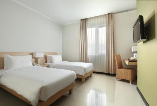 明古鲁省桑蒂卡明古鲁酒店的酒店客房设有两张床和电视。