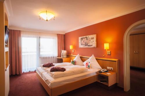 博登迈斯博尔霍夫维塔尔康体酒店的一间卧室配有一张橙色墙壁的床