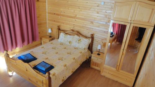 戈韦达尔齐BUNGALOWS SKI PISTA Govedarci的一间卧室设有一张床和木墙