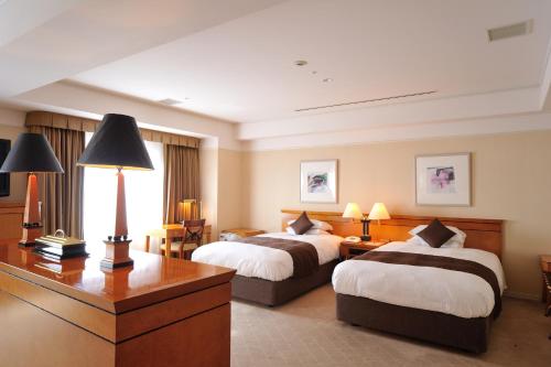 三原市广岛机场酒店 的酒店客房配有两张床和一张书桌