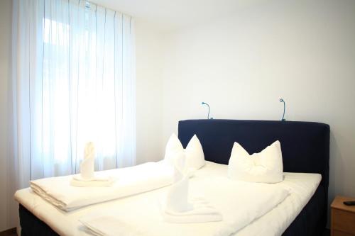 瓦尔内明德Ferienwohnung Warnemünde L (S)的卧室配有带白色枕头的床和窗户。