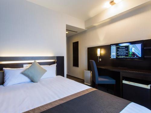 大阪新阪急大阪附楼酒店的酒店客房设有一张床、一张书桌和一台电视机。
