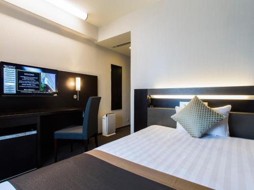 大阪新阪急大阪附楼酒店的酒店客房配有一张床、一张书桌和一台电视。