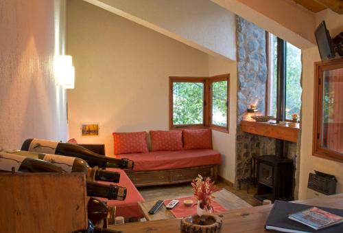 波特雷里约斯Las Espuelas Casas de Montaña的客厅设有红色的沙发和壁炉