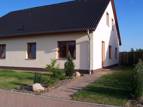 维斯马Ferienwohnung im Ostseeblick的黑色屋顶的白色房子