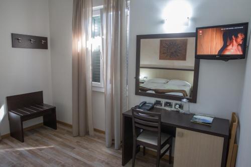 赫拉弗多纳劳罗酒店的客房设有书桌、镜子和床。