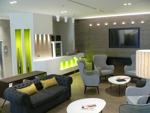 米兰索珀格酒店的客厅配有沙发、椅子和电视