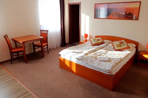 奥拉夫斯基波扎莫克Penzión Reduta的一间卧室配有一张床、一张桌子和一张书桌