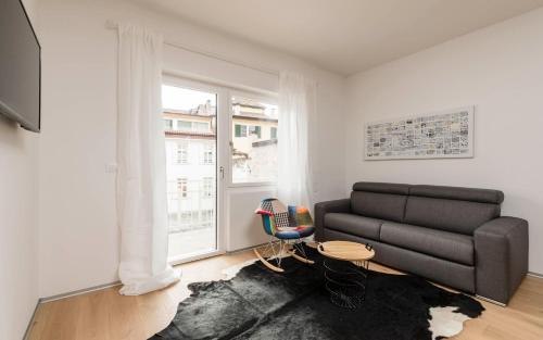 梅拉诺M-Loft merangardenvilla的带沙发和窗户的客厅