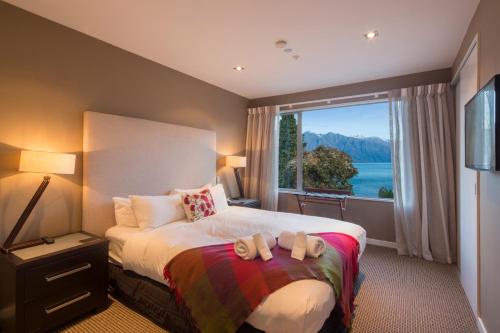 皇后镇LakeRidge Queenstown by Staysouth的一间卧室设有一张大床和大窗户
