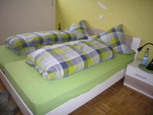科斯费尔德Ferienwohnung Keull的一张绿色的床,上面有两个枕头