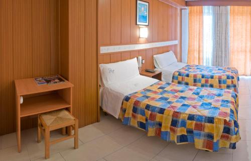 萨洛Pensión Venecia的小房间设有两张床和一张桌子