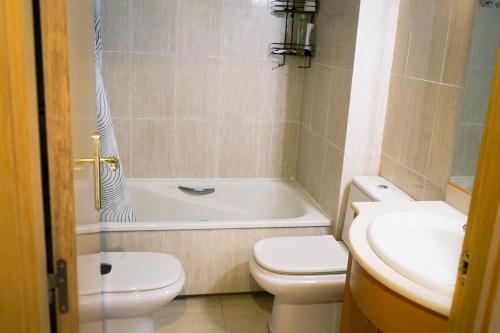 坎布里尔斯Apartamento Port Marino的浴室配有卫生间、浴缸和水槽。