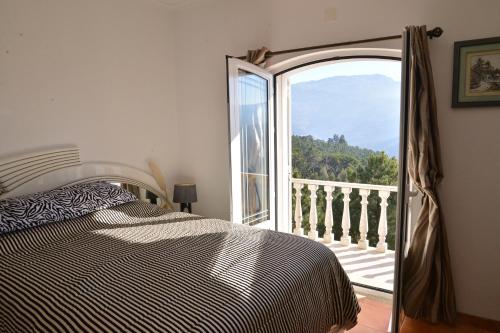 塞亚埃斯特雷拉德阿尔瓦旅馆的一间卧室设有一张床,并有通往阳台的门