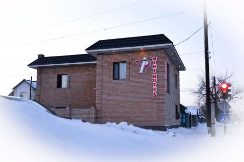 塞米伊VIP Mini Hotel的积雪上标有标志的砖砌建筑