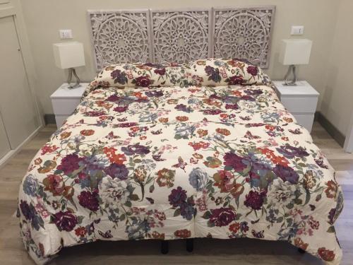 坎波巴索Dimora Spina in centro的一张带花卉床罩的床,上面有两盏灯