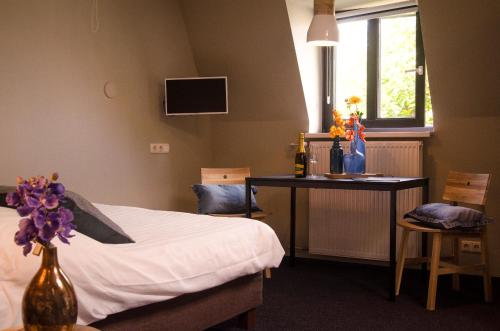 乌登让邦酒店的一间卧室配有一张床、一张桌子和一张书桌