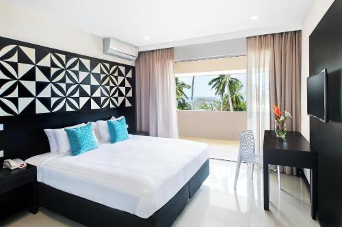 努库阿洛法塔诺阿国际日期变更线酒店 的一间卧室配有一张床、一张书桌和一个窗户。