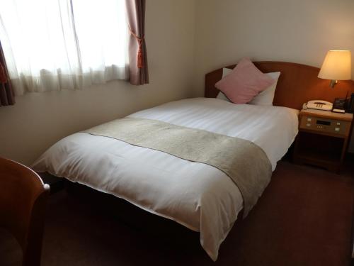IshiokaHotel Hashimotorou的卧室配有白色的床和窗户