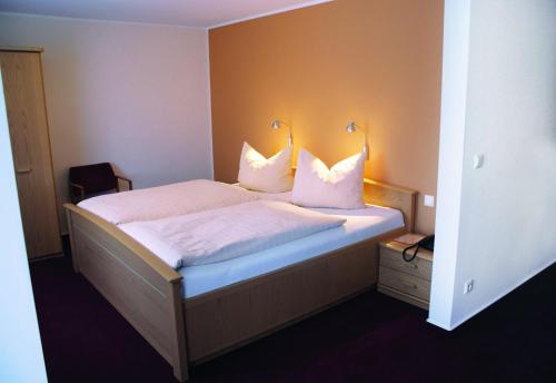巴特拉尔阳光商店之家旅馆的一间卧室配有带白色床单和枕头的床。