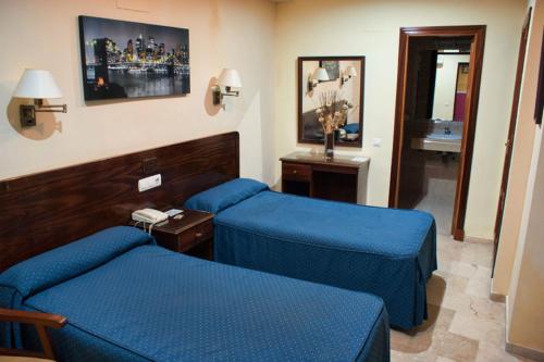 赫雷斯-德拉弗龙特拉新中心酒店的酒店客房设有2张蓝色的床和电话
