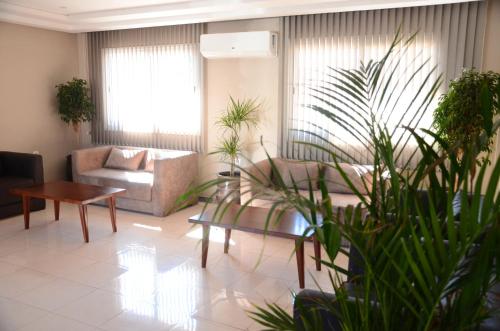 阿加迪尔Safar Budget的带沙发和桌子及植物的客厅