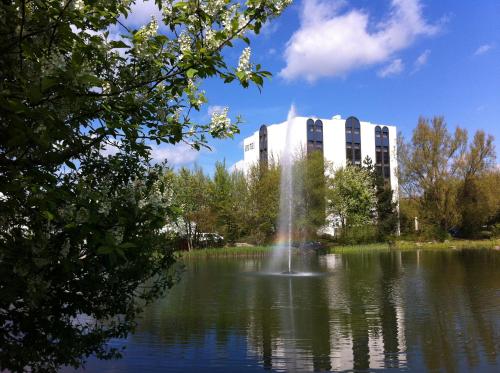 雷根斯堡ACHAT Hotel Regensburg im Park的一座建筑物前池塘里的喷泉