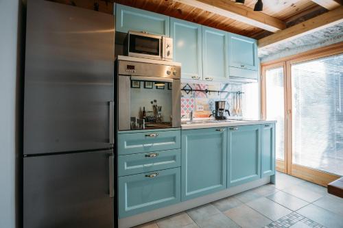 萨利Charming old stone house的厨房配有蓝色橱柜和不锈钢冰箱