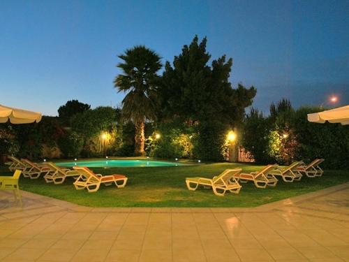 拉塞雷纳科斯塔皇家酒店的一群椅子坐在游泳池附近的草地上