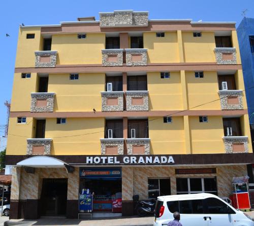 巴兰基亚Hotel Granada Inn的一座黄色建筑,带有酒店花岗岩