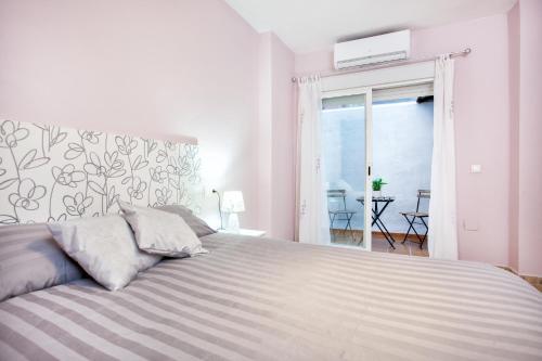 福恩吉罗拉Doña Elena的白色卧室设有一张大床和一个阳台