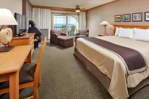 圣西米恩贝斯特韦斯特卡瓦利尔海滨度假酒店的酒店客房配有一张床、一张书桌和一台电视。