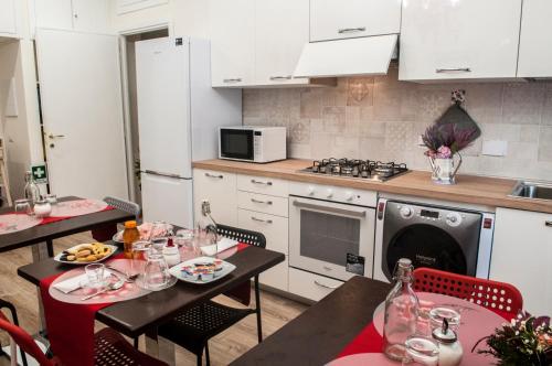 罗马卡萨迪本尼旅馆的一间带2张桌子的厨房和一间带白色橱柜的厨房