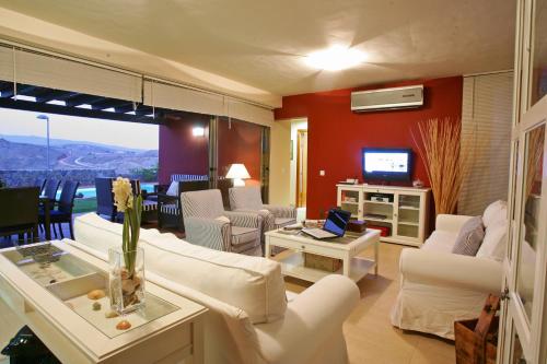马斯帕洛马斯萨洛布雷马斯特阳光别墅的客厅配有白色沙发和电视