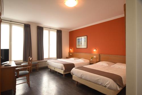 布兰肯贝赫萨博多尔酒店的橙色墙壁的酒店客房内的两张床