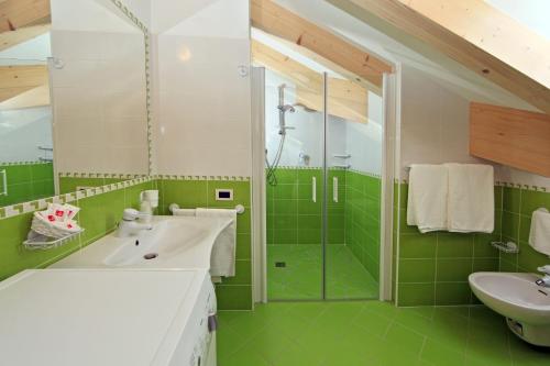 卡瓦莱塞Residence Garni Manuela的绿色浴室设有水槽和淋浴