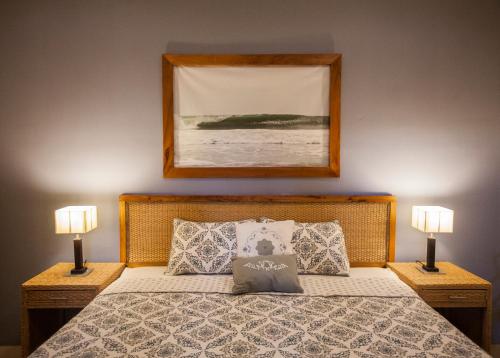 格拉纳达Hotel Plaza Marbella Granada的一间卧室配有一张带两盏灯和一张照片的床。
