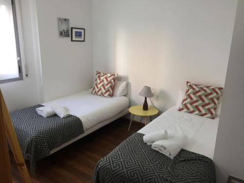略夫雷加特河畔奥斯皮塔莱特FIRA巴塞罗那公寓的客房设有两张床和一张带台灯的桌子。