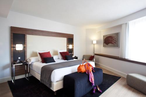 马德里Hotel Princesa Plaza Madrid的酒店客房设有一张大床和一张沙发。