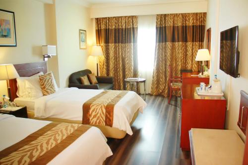 维杰亚瓦达Fortune Murali Park, Vijayawada - Member ITC's Hotel Group的酒店客房,配有两张床和椅子